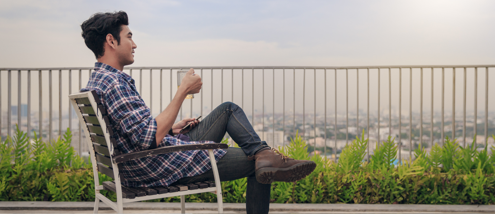 a man drinking a beer on a balcony